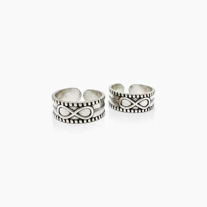 Two silver toe rings with infinity symbol design on a white background