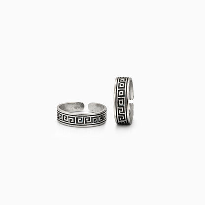 Two silver rings with Greek key design on a white background