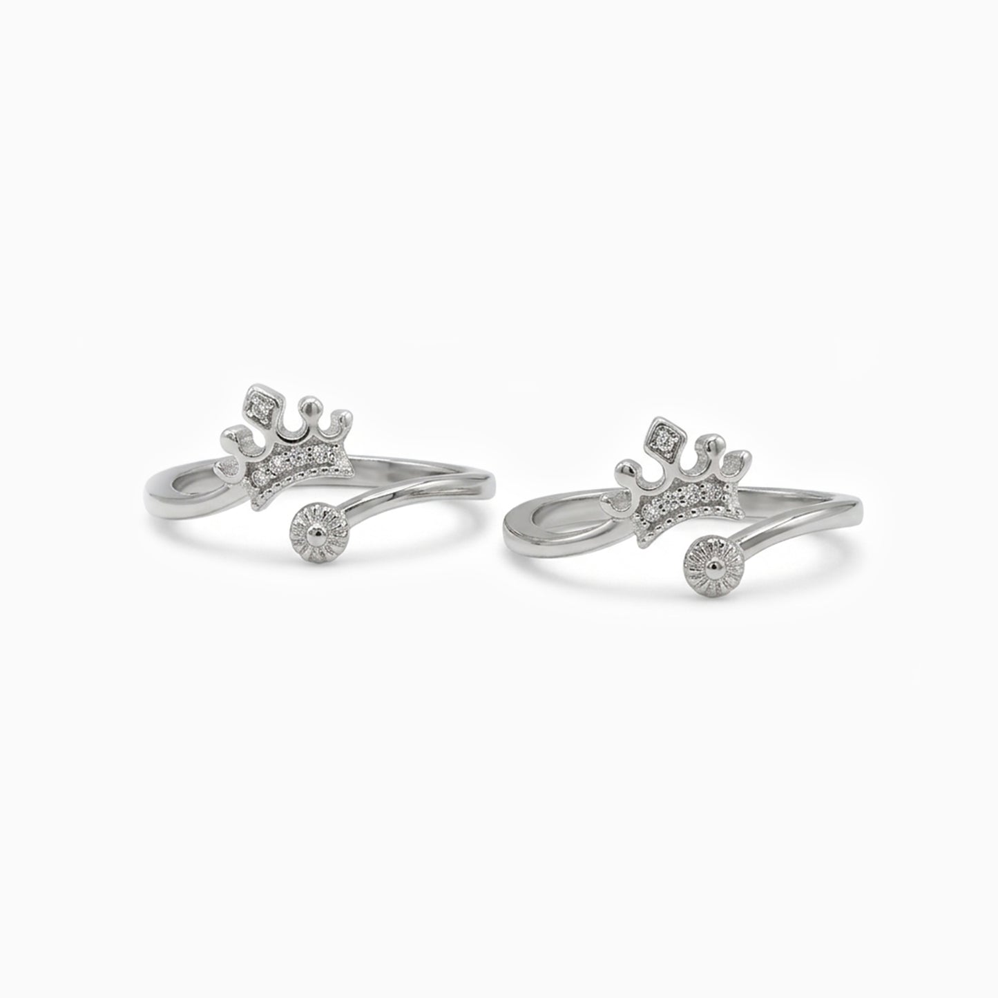 Pair of silver crown-shaped rings on a white background