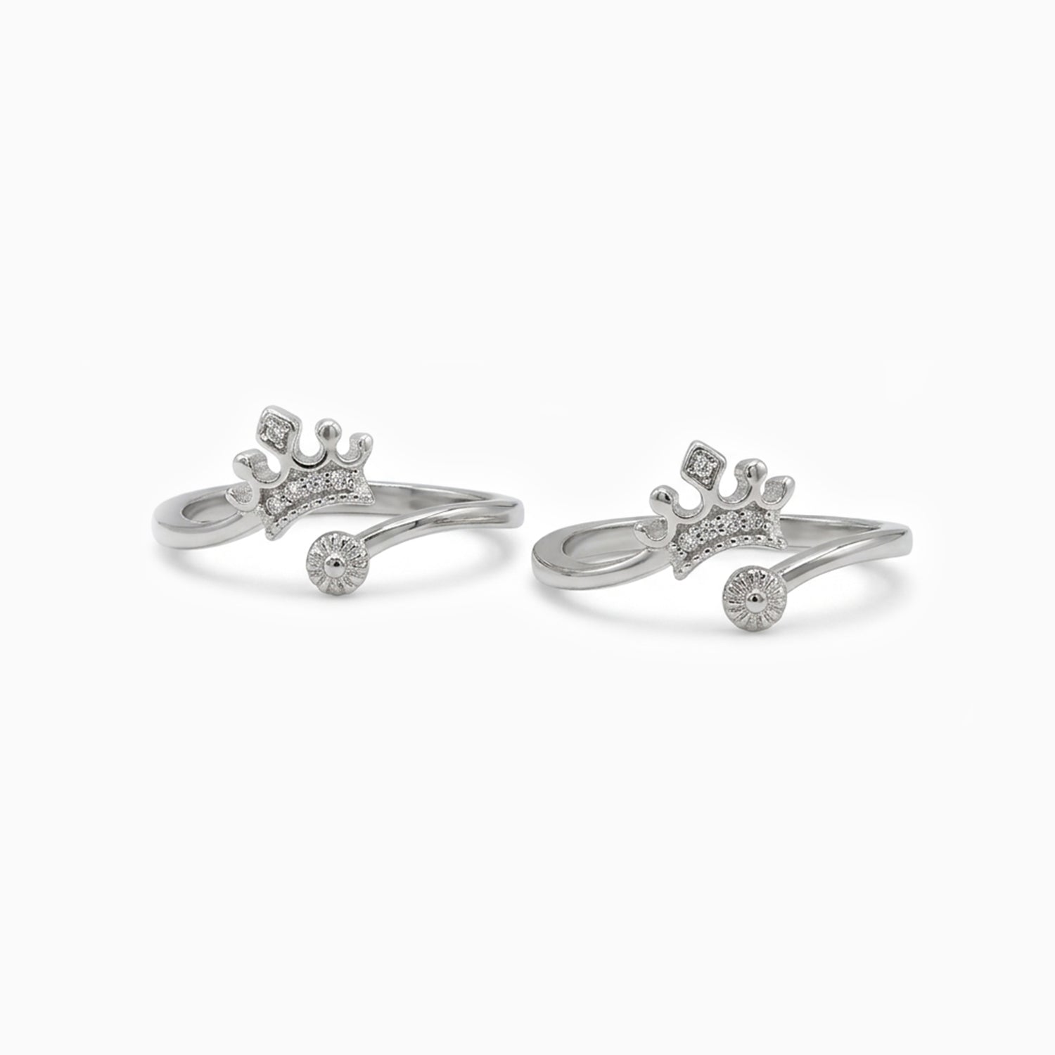 Pair of silver crown-shaped rings on a white background