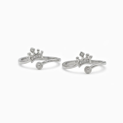 Pair of silver crown-shaped rings on a white background