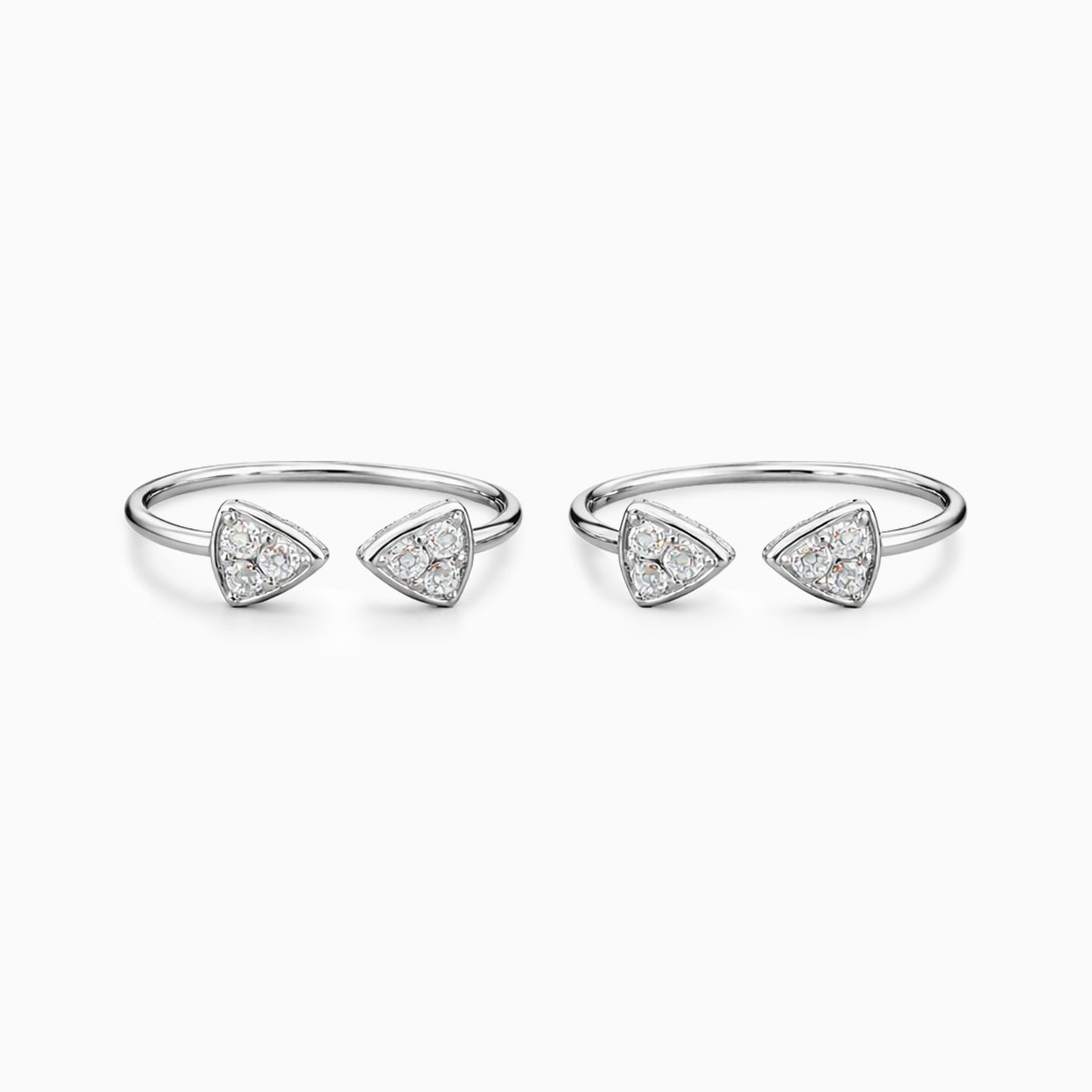 Set of four silver rings with triangle-shaped diamond accents on a white background