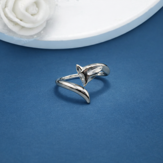 Silver ring on a blue background with a white flower in the corner