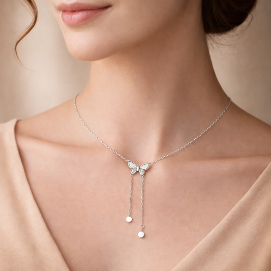 Silver butterfly necklace on a model with a neutral background