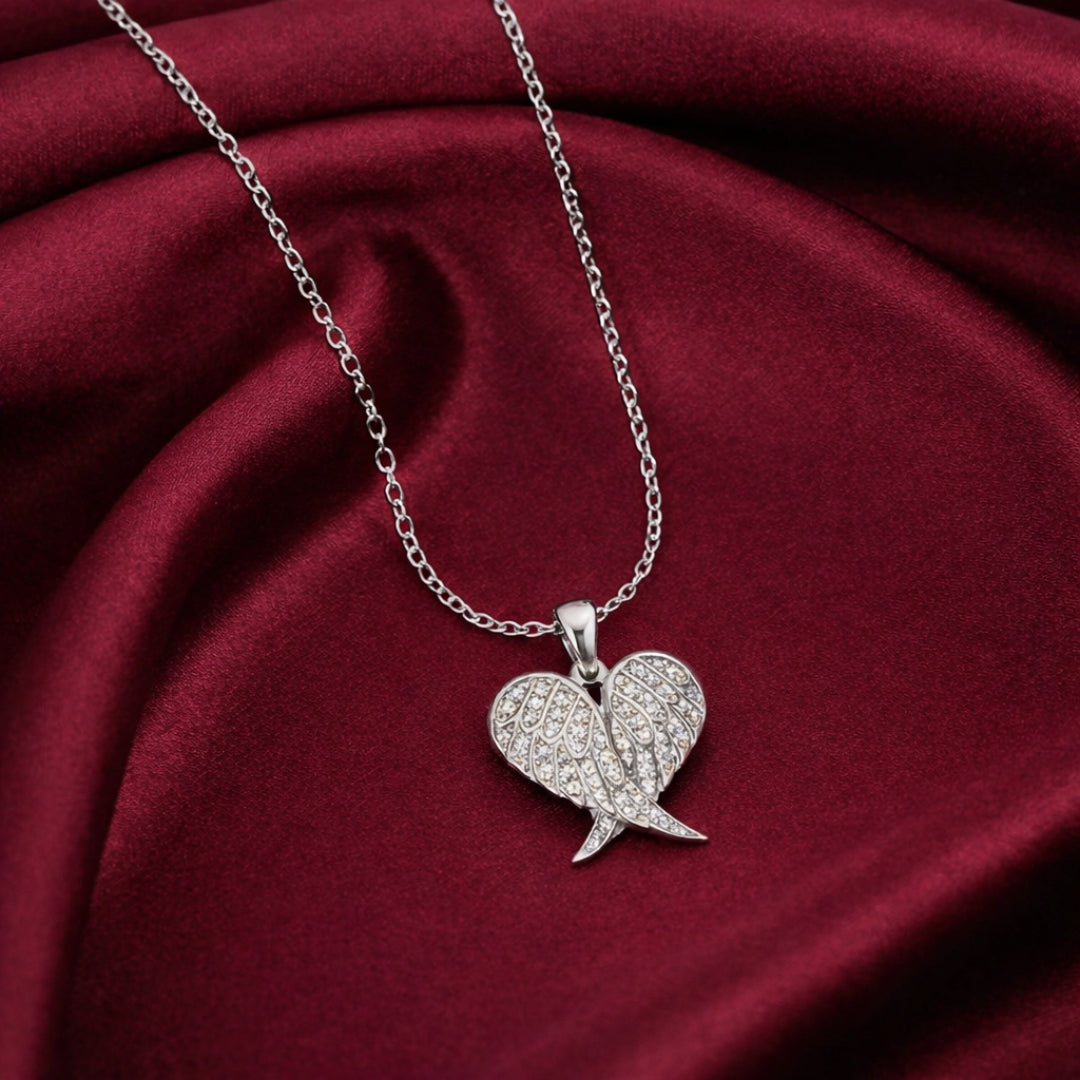 Silver wing-shaped pendant necklace on a red fabric background