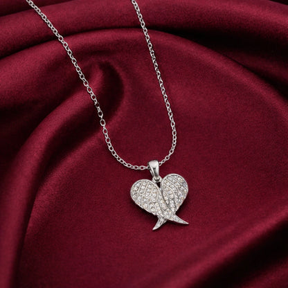 Silver wing-shaped pendant necklace on a red fabric background