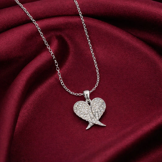 Silver wing-shaped pendant necklace on a red fabric background