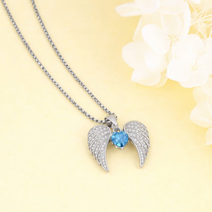 Necklace with angel wing pendant featuring a blue gemstone on a yellow background