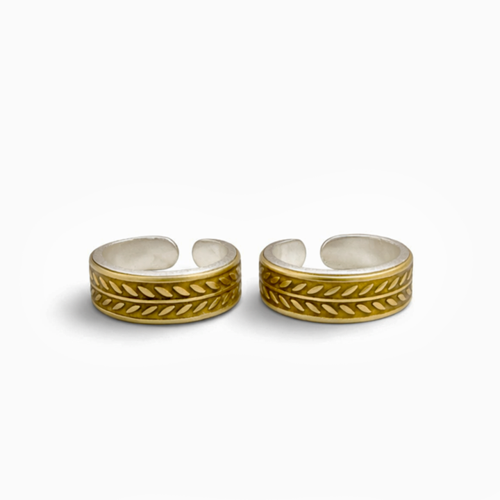 Pair of gold and silver open toe rings on a white background