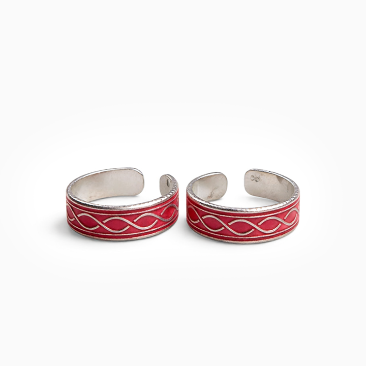 Pair of silver and red toe rings on a white background
