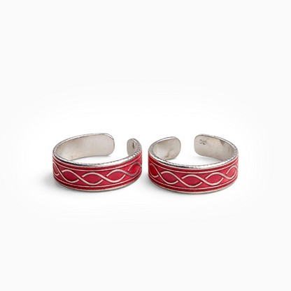 Pair of silver and red toe rings on a white background