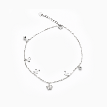 Silver bracelet with small charms on a white background