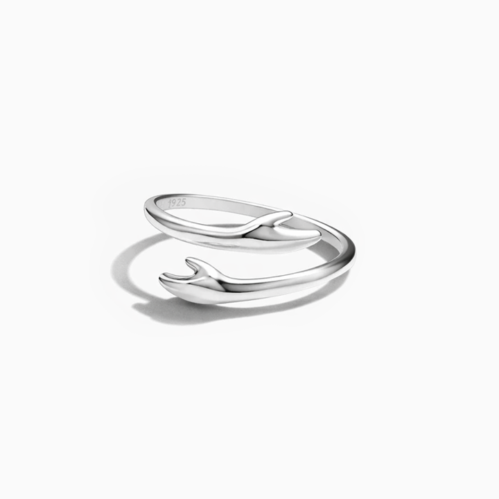 Silver ring with a whale design on a white background
