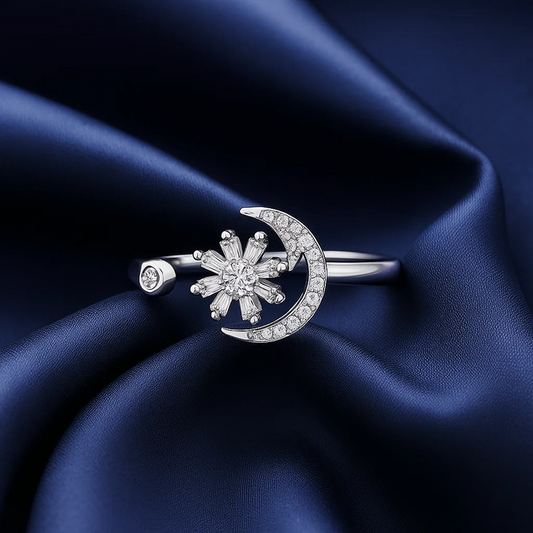 Silver ring with floral design and moon on blue satin fabric