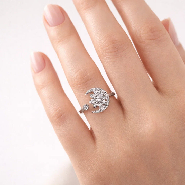 Silver ring with a crescent moon design on a hand against a white background