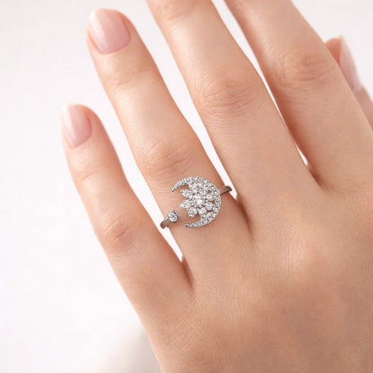 Silver ring with a crescent moon design on a hand against a white background