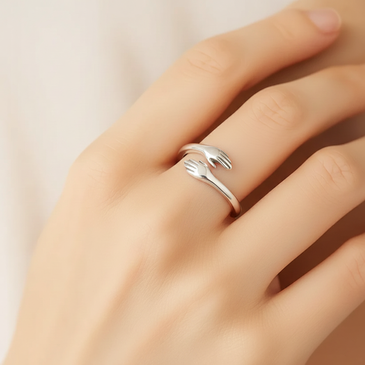 Silver ring on a person's finger against a neutral background