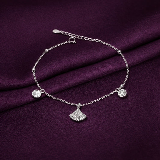 Silver bracelet with charms on a purple fabric background