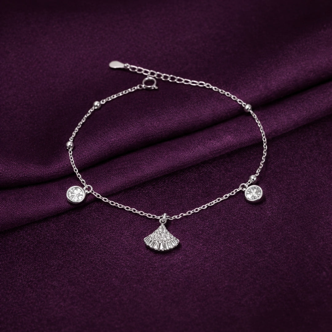 Silver bracelet with charms on a purple fabric background