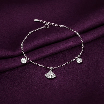 Silver bracelet with charms on a purple fabric background