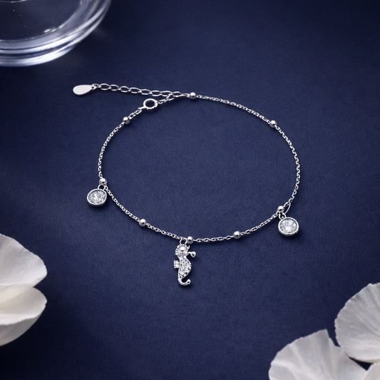 Silver bracelet with seahorse charm on a dark blue background