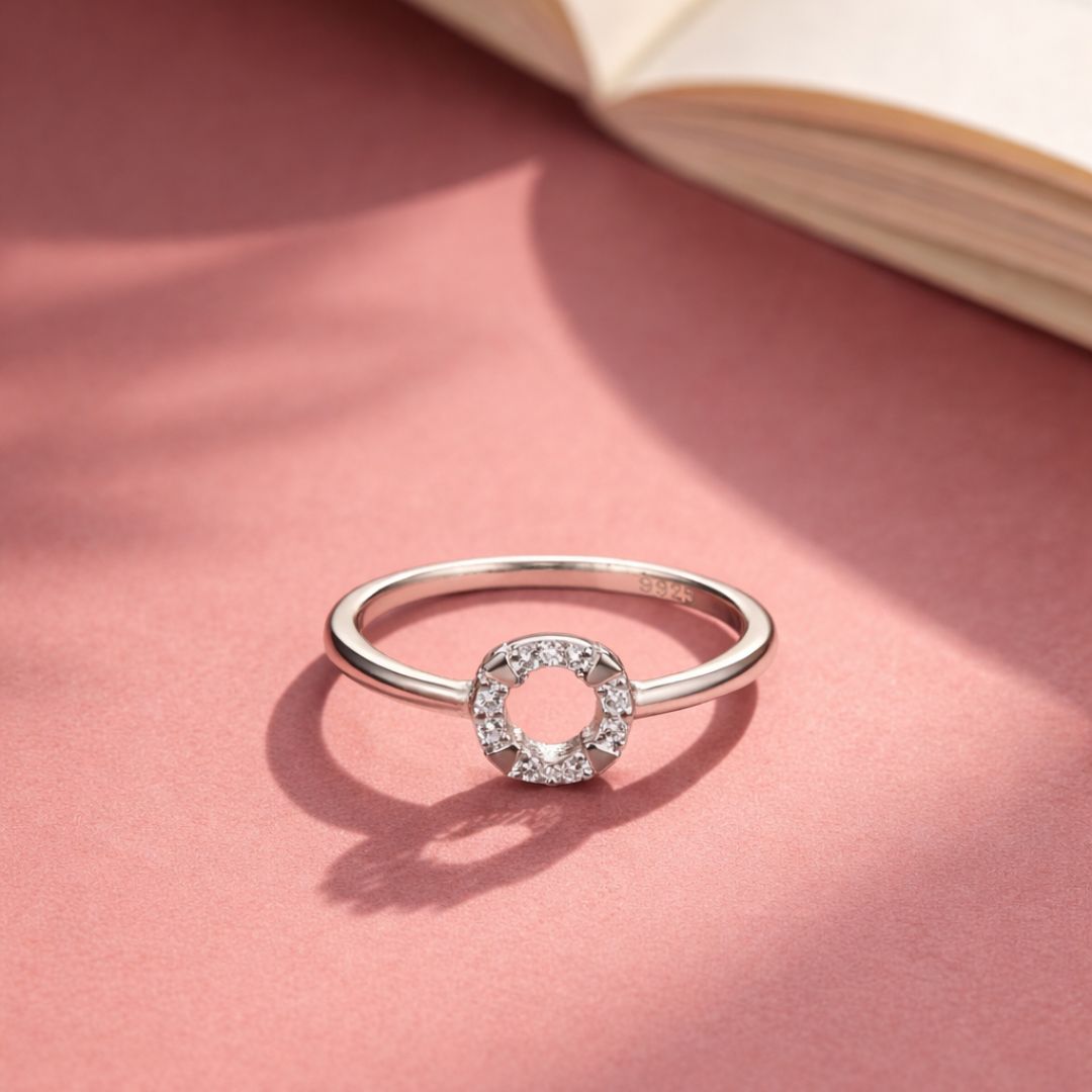 Silver ring with a circular design on a pink surface